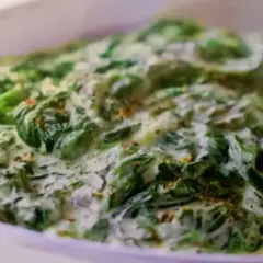 Un plat réconfortant d'épinards à la crème, parsemé d'épices, prêt à être dégusté.