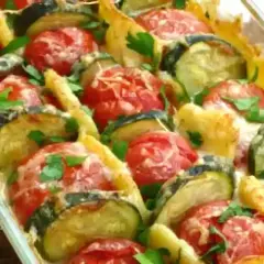 Un délicieux gratin de légumes, avec des rondelles de courgettes et de tomates, gratiné au fromage et parsemé de persil frais. Un plat savoureux et coloré.