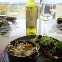 Un gratin de crozet savoureux, servi avec une salade fraîche et un verre de vin blanc. Un repas simple et délicieux.