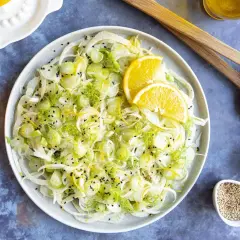 Salade de fenouil frais avec des tranches d'orange, du zeste et des graines de sésame noir. Un délice léger et croquant, parfait pour accompagner un plat.