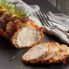 Un délicieux roti de porc Cookeo, tendre et juteux, servi avec de la moutarde à l'ancienne et des herbes fraîches.