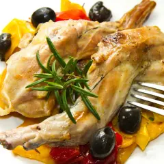 Délicieux lapin au Cookeo, servi avec des poivrons colorés, des olives noires et une touche de romarin frais.