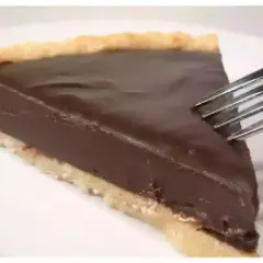 Une part de tarte au chocolat onctueuse, prête à être dégustée avec une fourchette.