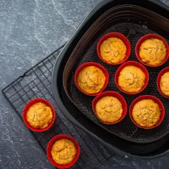 Petits gâteaux dorés dans des moules en silicone rouges, prêts à être dégustés après cuisson dans l'air fryer.