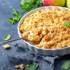 Un délicieux pâte à crumble aux pommes, garni de menthe fraîche et de bâtons de cannelle.