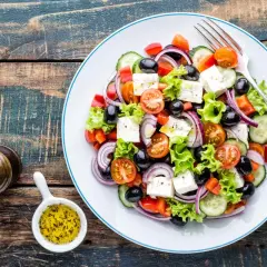 Salade grecque colorée avec feta, olives, tomates, concombre et oignons rouges. Une recette fraîche et légère.