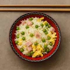 Un bol de riz cantonais, facile à préparer avec le Cookeo, garni de petits pois, dés de jambon et omelette.