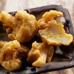Beignets de chou-fleur dorés et croustillants, servis sur un plateau. Un délice à croquer !