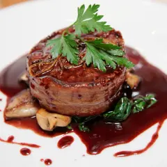 Un tendre filet de bœuf enrobé de lard, nappé d'une riche sauce marchand de vin, accompagné de champignons et d'épinards.
