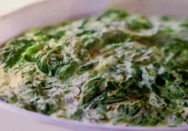 Un plat réconfortant d'épinards à la crème, parsemé d'épices, prêt à être dégusté.