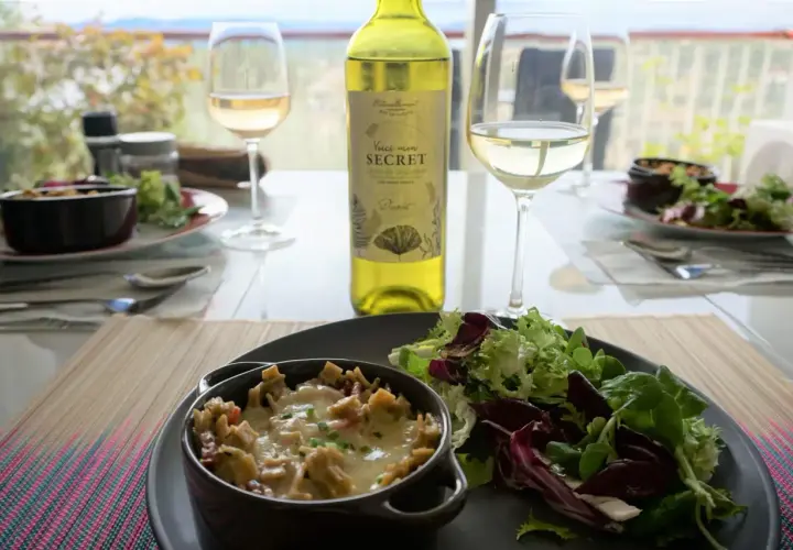 Un gratin de crozet savoureux, servi avec une salade fraîche et un verre de vin blanc. Un repas simple et délicieux.