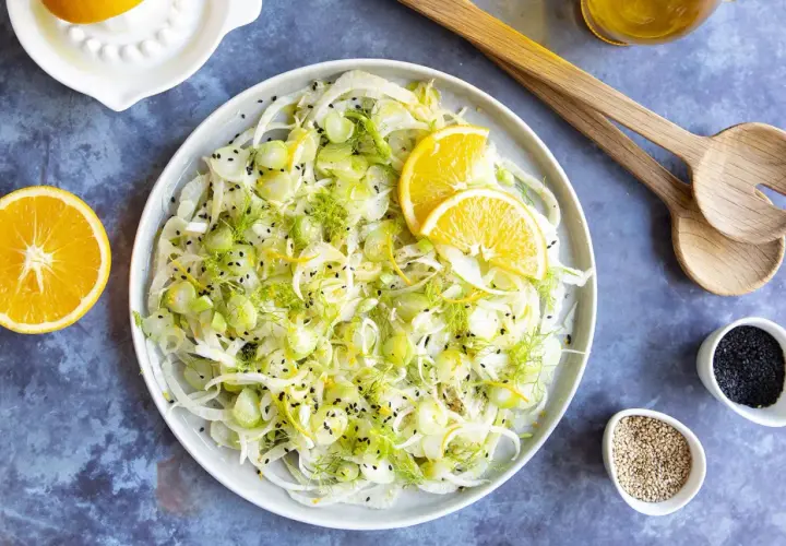 Salade de fenouil frais avec des tranches d'orange, du zeste et des graines de sésame noir. Un délice léger et croquant, parfait pour accompagner un plat.