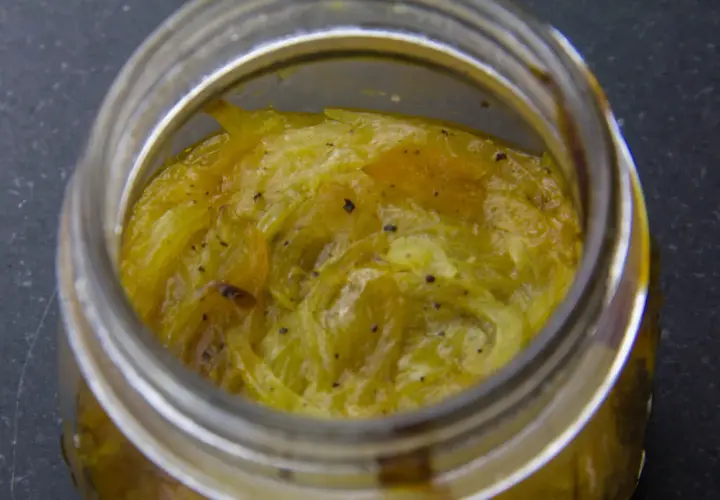 Compotée d'oignons caramélisés dans un bocal en verre, prête à être dégustée.