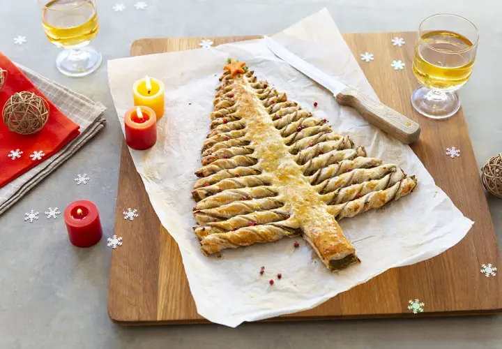 Une délicieuse entrée de Noël à faire la veille : un sapin feuilleté doré, décoré de baies roses, prêt à être dégusté.