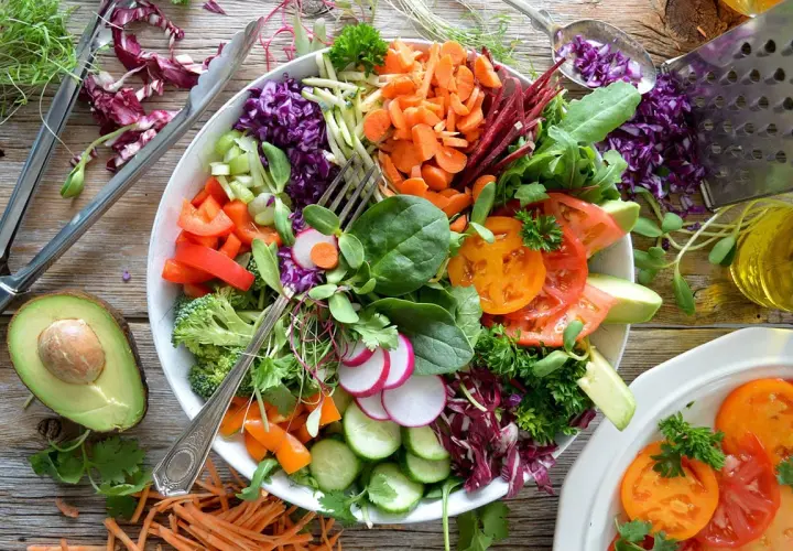 Une généreuse salade composée été, pleine de couleurs et de fraîcheur : tomates, avocat, carottes râpées, chou rouge, radis, concombre, brocolis et herbes fraîches.