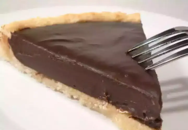 Une part de tarte au chocolat onctueuse, prête à être dégustée avec une fourchette.