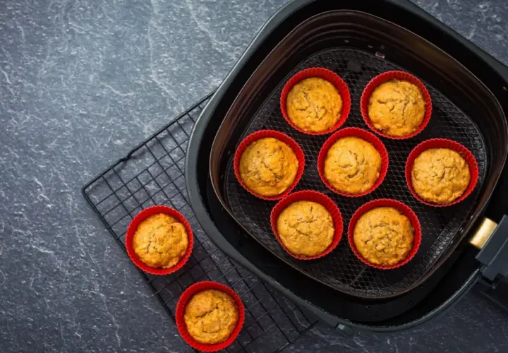 Petits gâteaux dorés dans des moules en silicone rouges, prêts à être dégustés après cuisson dans l'air fryer.