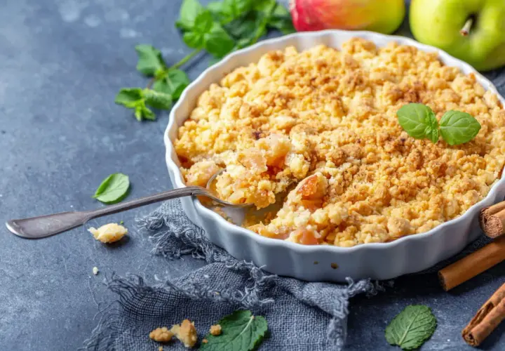 Un délicieux pâte à crumble aux pommes, garni de menthe fraîche et de bâtons de cannelle.