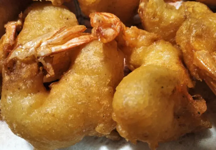 Gros plan sur des beignets de crevette dorés et croustillants, prêts à être dégustés.