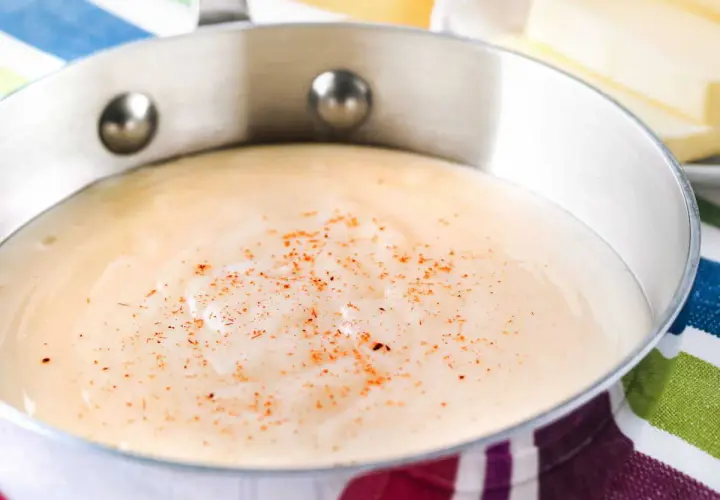 Sauce béchamel on a striped cloth, perfect for your recette béchamel pour lasagne.