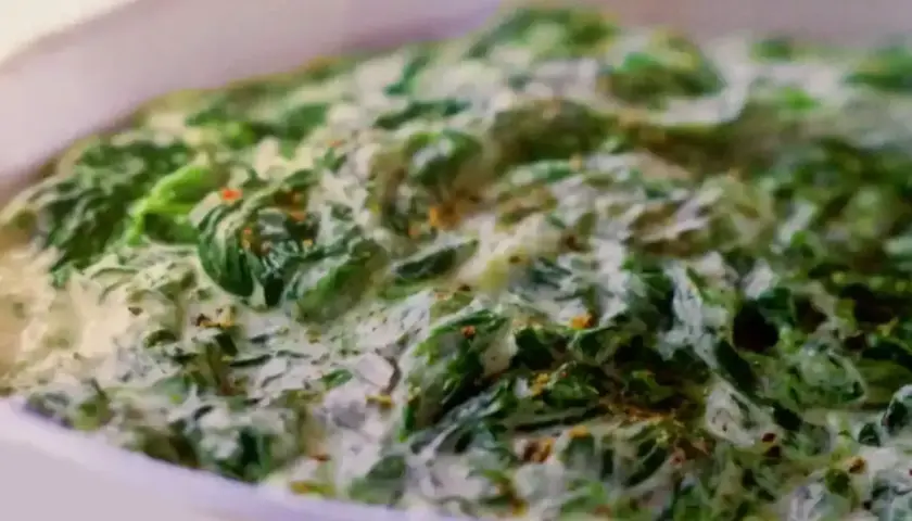 Un plat réconfortant d'épinards à la crème, parsemé d'épices, prêt à être dégusté.