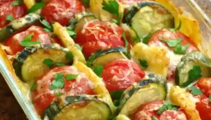 Un délicieux gratin de légumes, avec des rondelles de courgettes et de tomates, gratiné au fromage et parsemé de persil frais. Un plat savoureux et coloré.