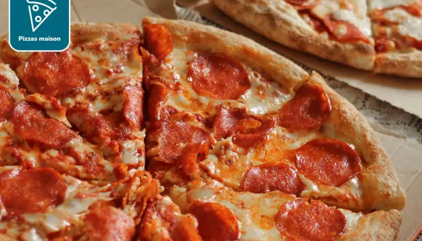 Deux pizzas au pepperoni, l'une coupée en parts, sur une pâte à pizza fine et croustillante.