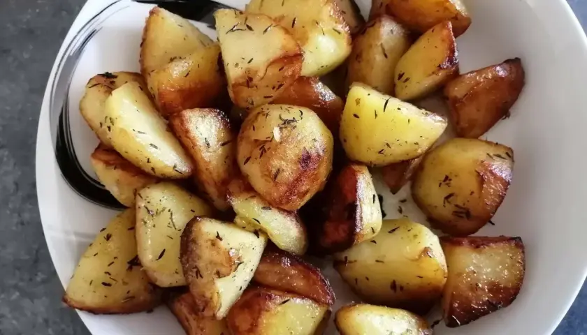 Pommes de terre rôties aux herbes, parfaitement dorées, prêtes à être dégustées. Un délice facile à préparer avec le Cookeo.
