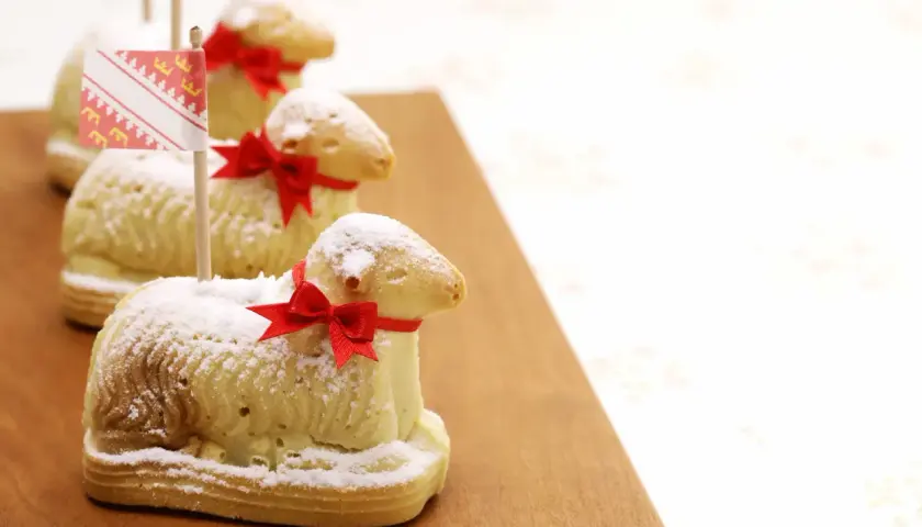 Trois agneaux en biscuit, saupoudrés de sucre glace et ornés de rubans rouges, rappellent la recette lamala grand-mère.