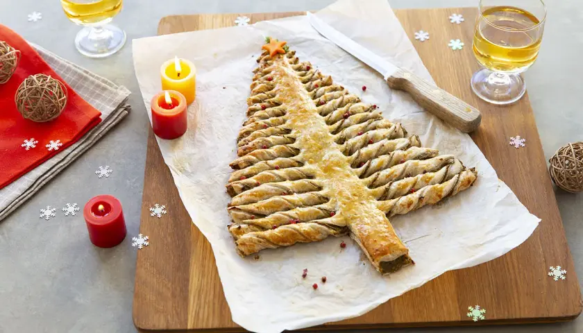 Une délicieuse entrée de Noël à faire la veille : un sapin feuilleté doré, décoré de baies roses, prêt à être dégusté.