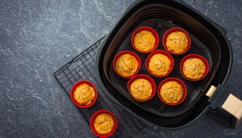 Petits gâteaux dorés dans des moules en silicone rouges, prêts à être dégustés après cuisson dans l'air fryer.