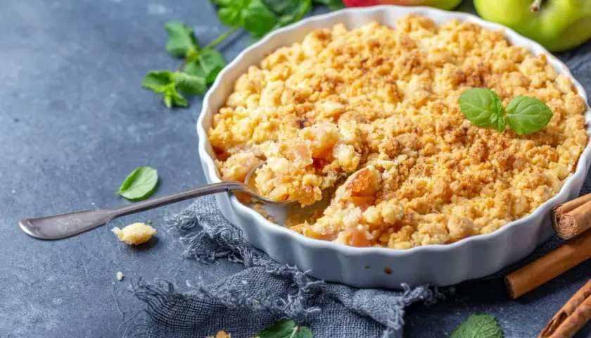 Un délicieux pâte à crumble aux pommes, garni de menthe fraîche et de bâtons de cannelle.