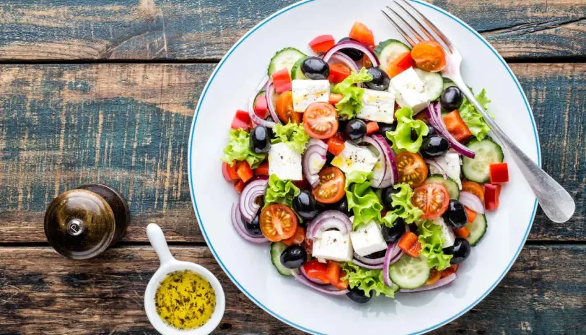 Salade grecque colorée avec feta, olives, tomates, concombre et oignons rouges. Une recette fraîche et légère.