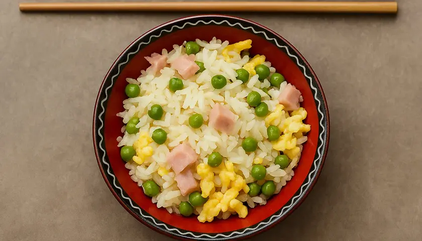 Un bol de riz cantonais, facile à préparer avec le Cookeo, garni de petits pois, dés de jambon et omelette.
