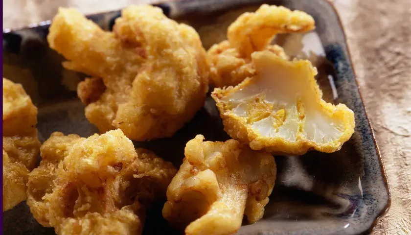 Beignets de chou-fleur dorés et croustillants, servis sur un plateau. Un délice à croquer !