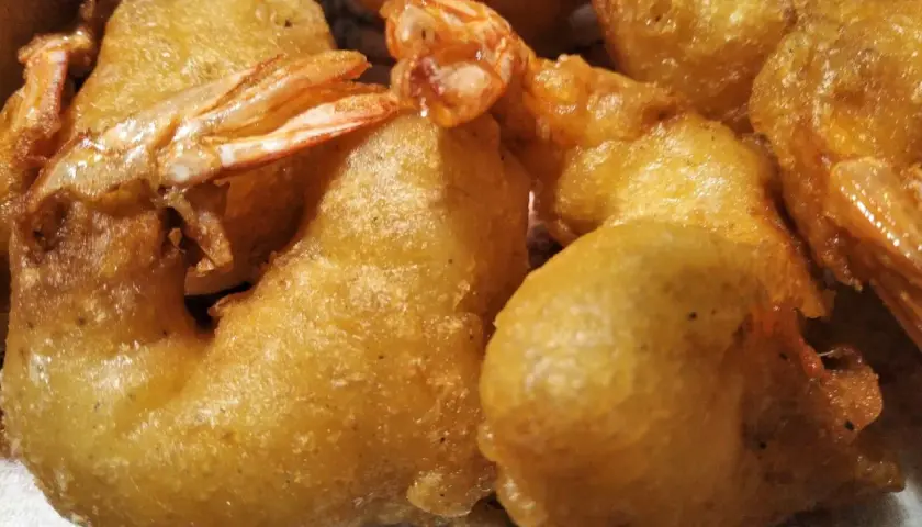 Gros plan sur des beignets de crevette dorés et croustillants, prêts à être dégustés.