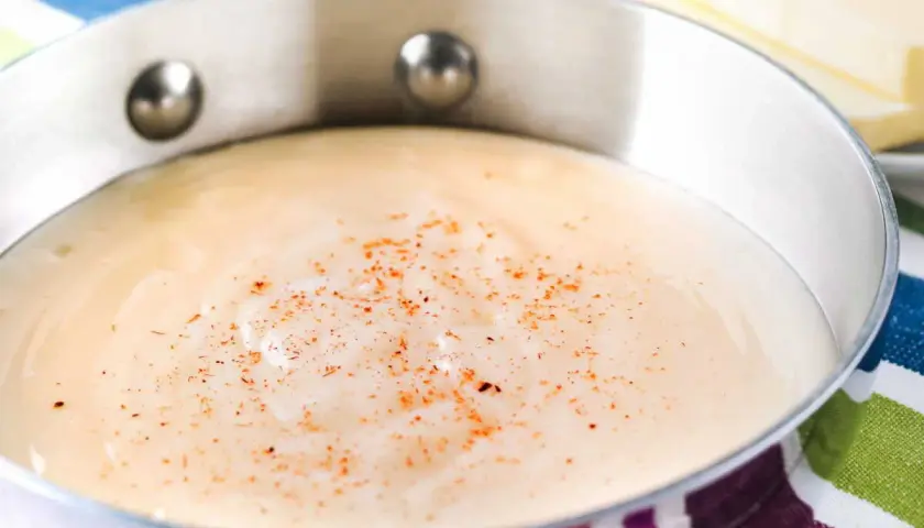 Sauce béchamel on a striped cloth, perfect for your recette béchamel pour lasagne.