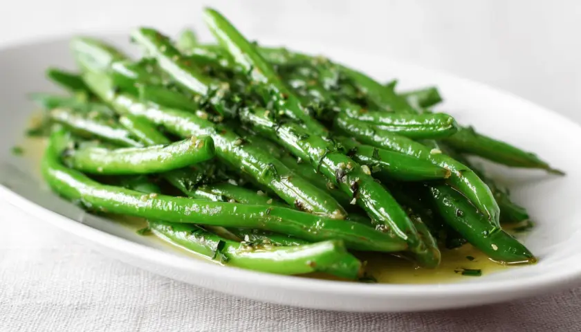 Haricots verts frais, brillants et assaisonnés, parfaits pour une recette haricot vert simple et savoureuse.