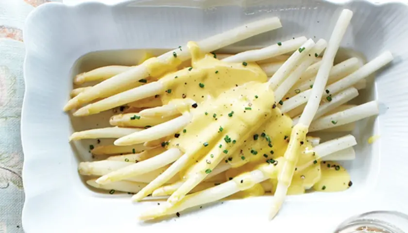 Asperges blanches tendres nappées d'une sauce crémeuse et garnies de ciboulette. Un délice printanier à déguster avec cette sauce pour asperges blanches.