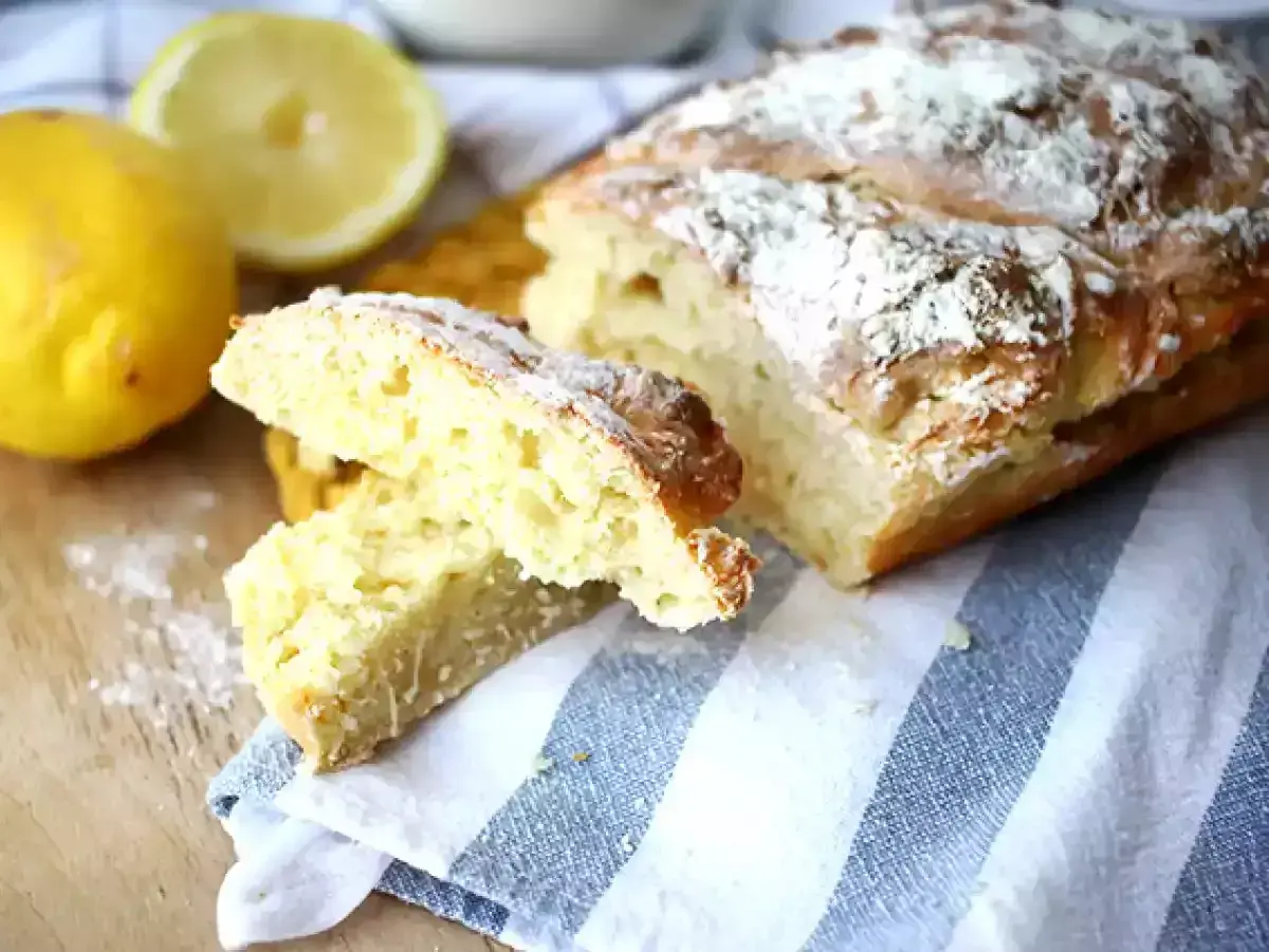 Pain sans levure, doré et saupoudré de farine, avec des citrons frais à côté.