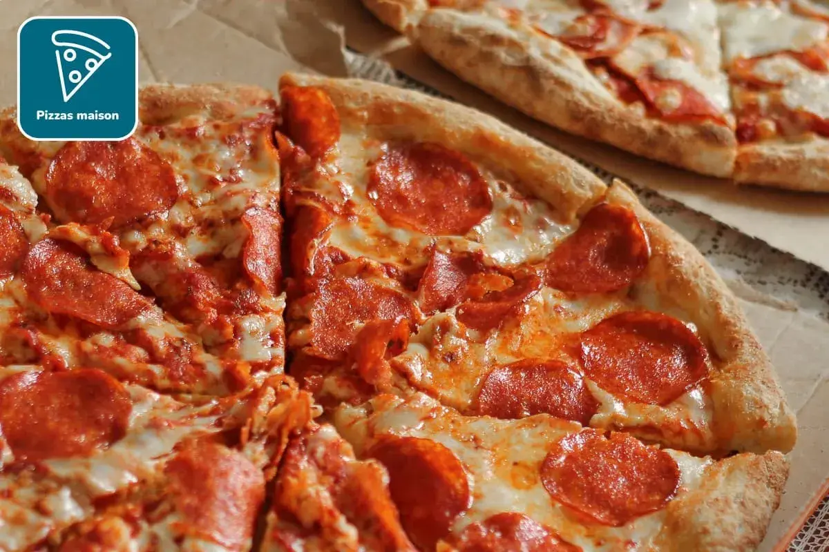 Deux pizzas au pepperoni, l'une coupée en parts, sur une pâte à pizza fine et croustillante.