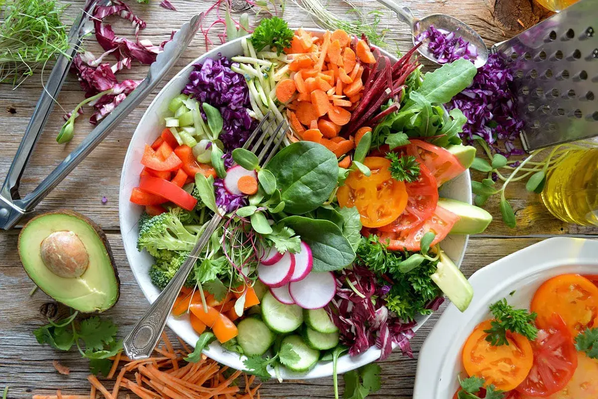 Une généreuse salade composée été, pleine de couleurs et de fraîcheur : tomates, avocat, carottes râpées, chou rouge, radis, concombre, brocolis et herbes fraîches.