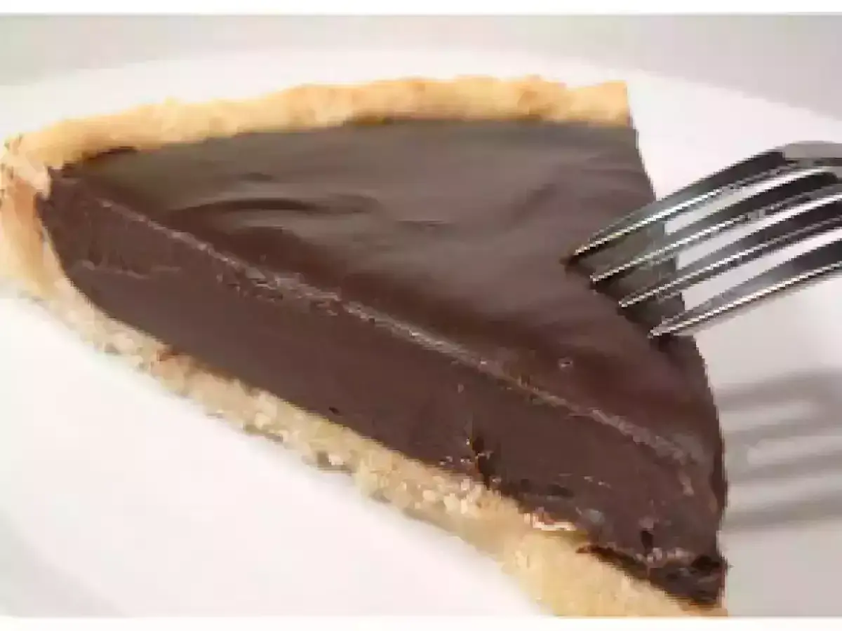 Une part de tarte au chocolat onctueuse, prête à être dégustée avec une fourchette.