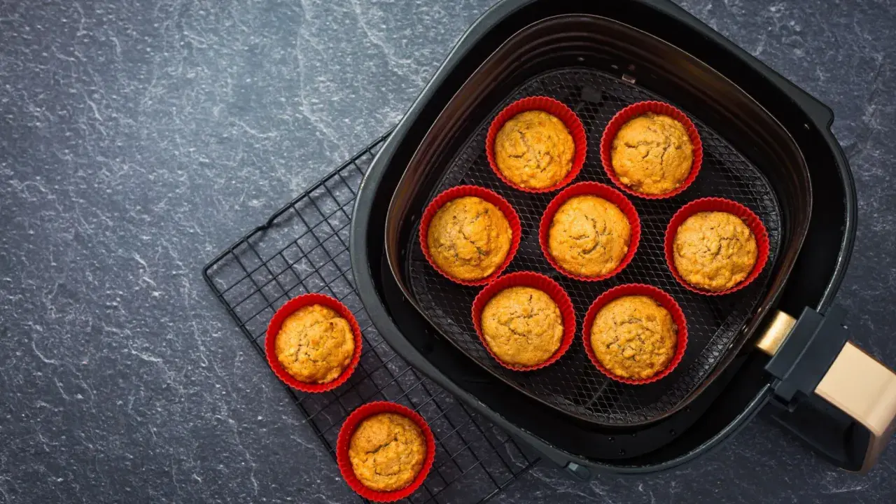 Petits gâteaux dorés dans des moules en silicone rouges, prêts à être dégustés après cuisson dans l'air fryer.