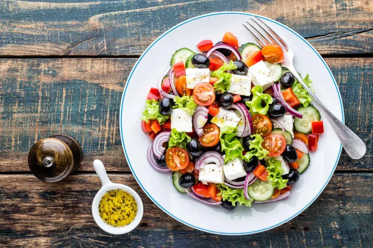 Salade grecque colorée avec feta, olives, tomates, concombre et oignons rouges. Une recette fraîche et légère.