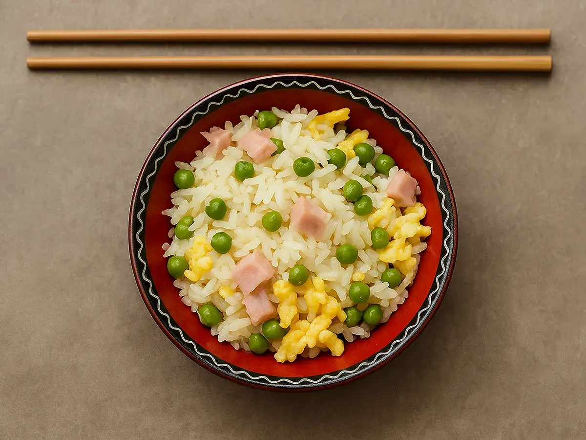 Un bol de riz cantonais, facile à préparer avec le Cookeo, garni de petits pois, dés de jambon et omelette.