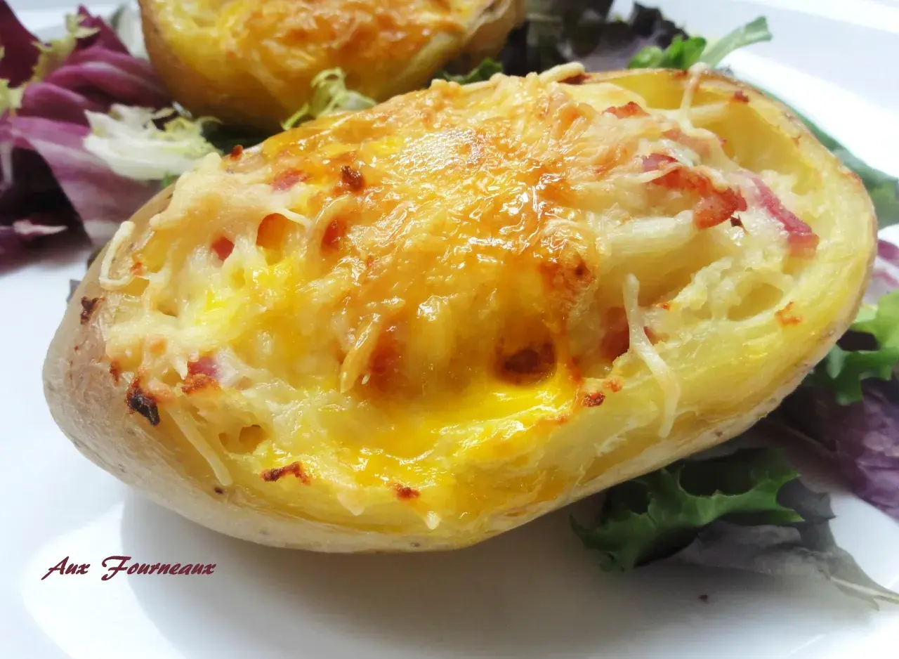Une pomme de terre farcie, gratinée au fromage et garnie de lardons, servie avec une salade verte.