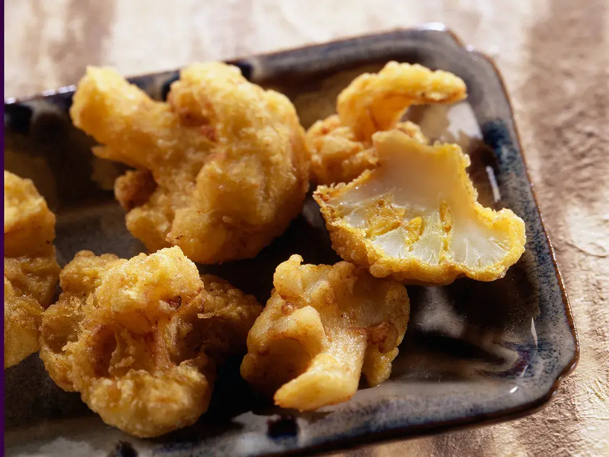 Beignets de chou-fleur dorés et croustillants, servis sur un plateau. Un délice à croquer !
