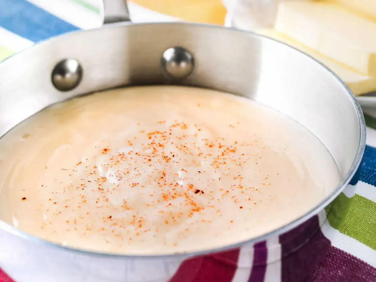 Sauce béchamel on a striped cloth, perfect for your recette béchamel pour lasagne.