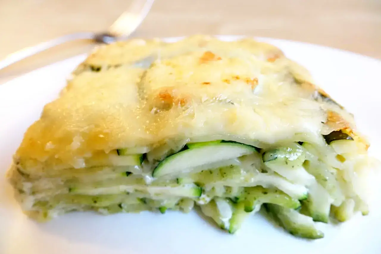 Un gratin de ravioles et courgettes, fondant et doré, prêt à être dégusté.